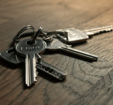 A close-up of a set of metal keys resting on a wooden surface.
