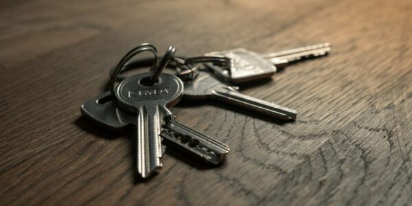 A close-up of a set of metal keys resting on a wooden surface.